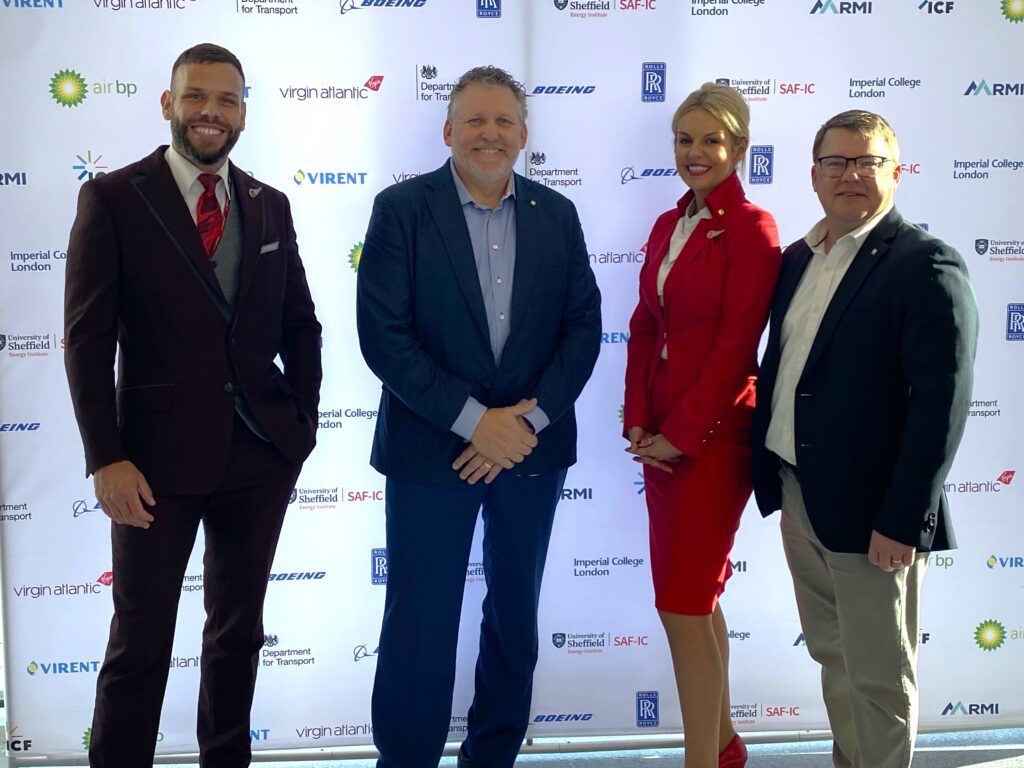 Bob Rozmiarek poses for a photo with two flight attendants prior to the historic Virgin Atlantic fligh